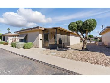 Charming single-story home featuring low-maintenance landscaping and a cozy screened-in porch at 13621 N 98Th Ave # E, Sun City, AZ 85351