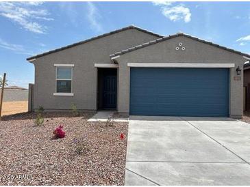 Charming single-story home with a two-car garage, well-maintained landscaping, and a welcoming facade at 17409 W Eva St, Waddell, AZ 85355