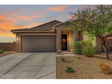 Charming single-story home with a two car garage, desert landscaping, and a welcoming front entrance at 17532 W Copper Ridge Dr, Goodyear, AZ 85338