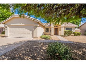 Charming single-story home with desert landscaping and a two-car garage at 1821 N 74Th Pl, Mesa, AZ 85207