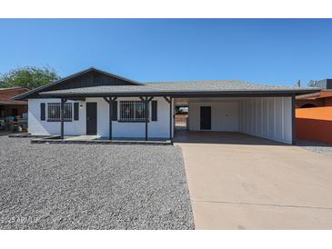 Charming single-story home featuring a gravel front yard, covered porch, and attached carport at 5336 W Lewis Ave, Phoenix, AZ 85035