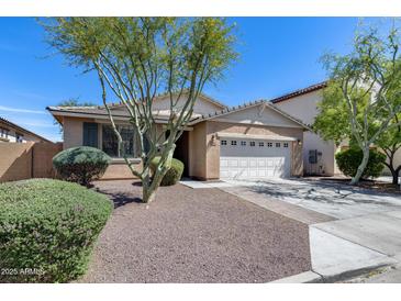 Charming single-story home featuring a well-maintained front yard, two-car garage, and desert landscaping at 7634 W Redbird Rd, Peoria, AZ 85383