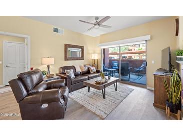 Inviting living room with comfortable leather seating and access to outdoor patio at 14950 W Mountain View Blvd # 7111, Surprise, AZ 85374