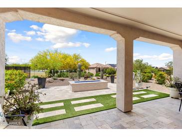 Inviting backyard with blue fire pit, artificial turf, and desert landscaping at 21090 N 267Th Dr, Buckeye, AZ 85396