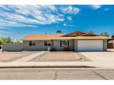 Charming single-story home featuring a two-car garage and xeriscaped front yard for low maintenance appeal at 2327 E Pebble Beach Dr, Tempe, AZ 85282