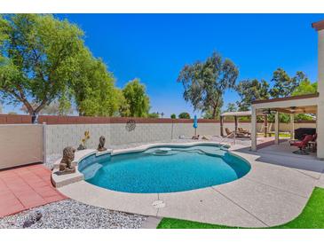 Backyard pool area with seating area and lush green grass at 2454 W Camp River Rd, Queen Creek, AZ 85144