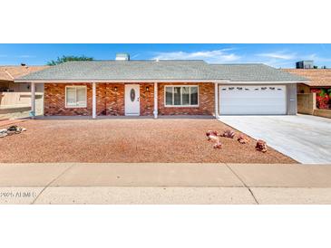Charming single-story brick home featuring a well-manicured front yard and an attached two-car garage at 4310 E Sacaton St, Phoenix, AZ 85044