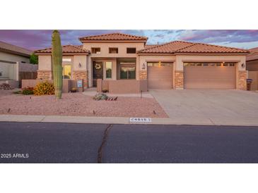 Beautiful beige home with a tile roof, 2-car garage, desert landscaping, and stone accents on the facade at 4615 S Primrose Dr, Gold Canyon, AZ 85118