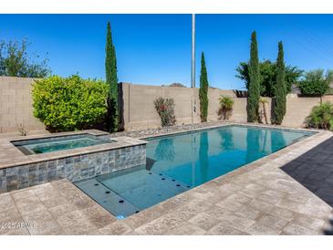Inviting backyard pool and spa surrounded by lush landscaping and a serene desert ambiance at 5826 W Plum Rd, Phoenix, AZ 85083