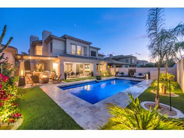 Inviting backyard with a sparkling pool, lounge area, and lush landscaping, perfect for outdoor entertaining at 7438 E San Jacinto Dr, Scottsdale, AZ 85258