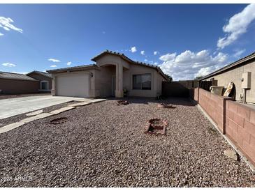 Single-story home featuring desert landscaping, neutral stucco exterior, and an attached two-car garage at 7664 W Vermont Ave, Glendale, AZ 85303