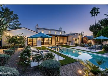 A stunning backyard features a modern pool and spa, lush landscaping, and outdoor living space at 7902 E Via Linda --, Scottsdale, AZ 85258