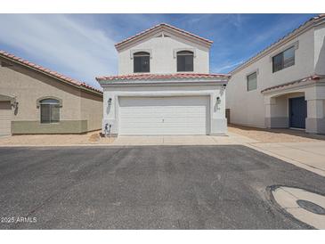 Two-story home featuring a two-car garage, red tile roof, and manicured front yard at 1750 W Union Hills Dr # 8, Phoenix, AZ 85027