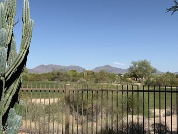 Scenic golf course view framed by a metal fence and desert landscape, mountains visible in the background at 22231 N 51St St, Phoenix, AZ 85054
