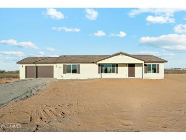 Charming single-story home with a two-car garage, desert landscaping, and a neutral color palette at 22387 S Manzanilla Rd, Buckeye, AZ 85326