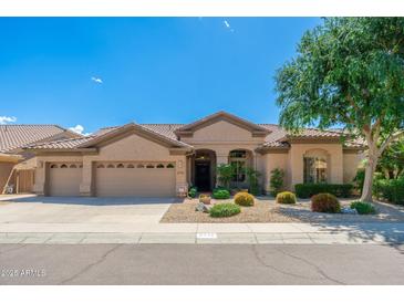 Charming single-story home featuring a three-car garage, desert landscaping, and a tiled roof at 6135 E Campo Bello Dr, Scottsdale, AZ 85254