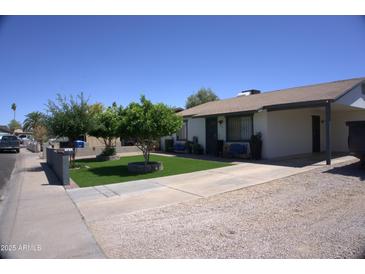 Pleasant single story home with manicured lawn, mature landscaping, and covered carport at 6725 W Cypress St, Phoenix, AZ 85035