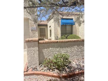 Charming front exterior with brick accents, blue awning, and mature landscaping at 9406 S 47Th Pl, Phoenix, AZ 85044