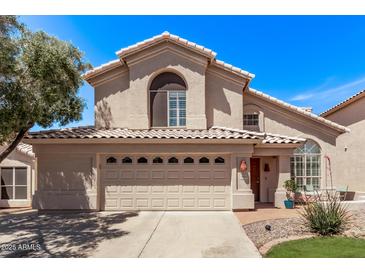 Inviting two-story home with a large, arched window, a three-car garage, and well-maintained landscaping at 13270 N 93Rd Way, Scottsdale, AZ 85260