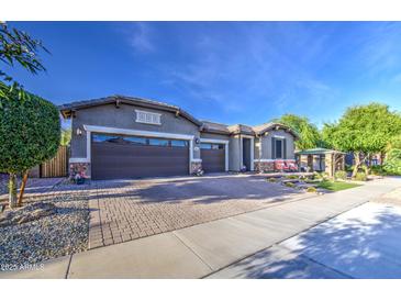 Beautiful single-Gathering home with three-car garage and landscaped front yard on a bright day at 16042 W Shaw Butte Dr, Surprise, AZ 85379