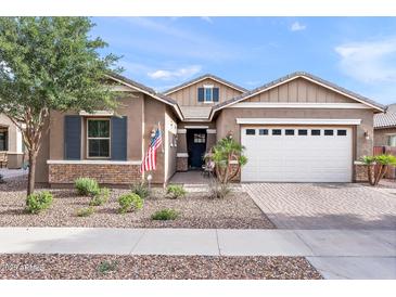Charming single-Gathering home featuring a two-car garage, a stone facade, and a well-maintained front yard at 20563 E Carriage Way, Queen Creek, AZ 85142