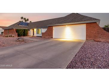 Charming single-story home with a brick accent, two-car garage and desert landscaping at 2259 E Ivy St, Mesa, AZ 85213