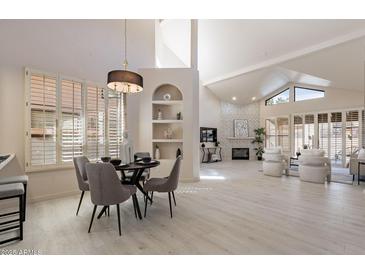 Bright, open living space with vaulted ceilings, a fireplace, and floor-to-ceiling shutters at 4116 E Sunnyside Dr, Phoenix, AZ 85028