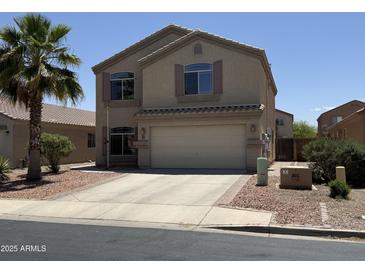 Charming two-story home with a two car garage, desert landscaping, and a beautiful palm tree at 42775 W Jeremy St, Maricopa, AZ 85138