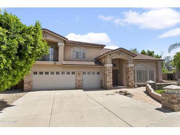 A beautiful two-story stucco home with a three-car garage and stone facade at 7340 W Bronco Trl, Peoria, AZ 85383