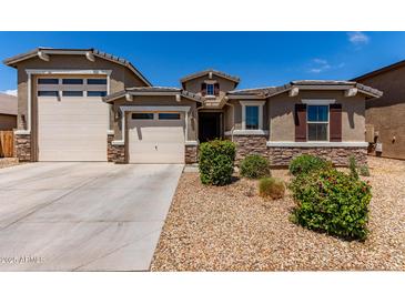 Charming single-story home with a well-manicured front yard, stone accents, and a three-car garage at 8010 W Atlantis Way, Phoenix, AZ 85043