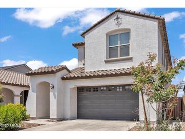 Inviting two-story home showcasing a gray garage door, covered front entry, and well-manicured landscaping at 9444 W Roma Ave, Phoenix, AZ 85037