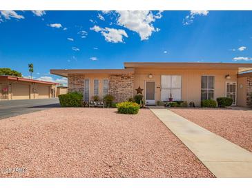 Charming single-story home featuring a well-maintained yard and inviting walkway, creating a warm and welcoming entrance at 10161 W Thunderbird Blvd, Sun City, AZ 85351