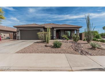 Charming single-story home featuring desert landscaping, a two-car garage, and a covered front porch at 11611 N 149Th Ln, Surprise, AZ 85379