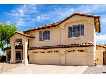 Charming two-story home featuring a red tile roof and a spacious three-car garage at 12853 E Yucca St, Scottsdale, AZ 85259