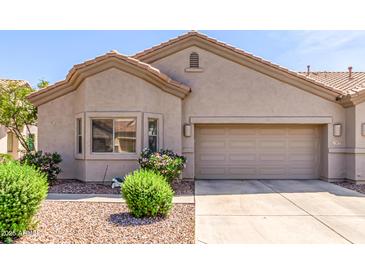 Charming single-story home with a two-car garage, desert landscaping, and a neutral color palette at 1577 E Earl Dr, Casa Grande, AZ 85122