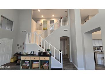 Bright foyer with stairs and white railing leading to the upper level, creating an inviting entry at 16046 W Hearn Rd, Surprise, AZ 85379