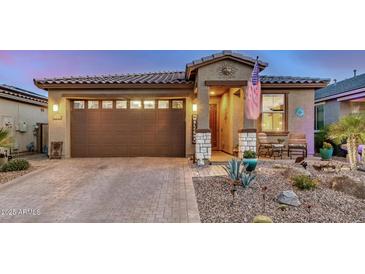 Charming home featuring a two-car garage, landscaped front yard, and cozy porch area at 17419 W Georgia Dr, Surprise, AZ 85388