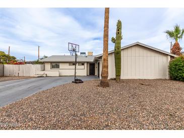 Charming single-story home with a desert landscaped yard and a basketball hoop at 2001 W Surrey Ave, Phoenix, AZ 85029