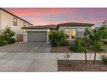 Charming home featuring a gray stucco exterior, a gray garage door, and lovely curb appeal at 22609 E Roundup Way, Queen Creek, AZ 85142