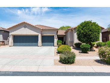Charming home boasts a well-manicured front yard, complemented by a spacious three-car garage at 2310 W Sienna Bouquet Pl, Phoenix, AZ 85085