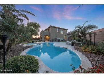 Inviting backyard pool and spa with desert landscaping and a covered patio, perfect for outdoor living at 29966 N 72Nd Dr, Peoria, AZ 85383