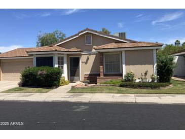 Inviting single-story home featuring a well-manicured lawn and classic architectural details at 314 E Campo Bello Dr, Phoenix, AZ 85022