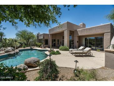 Inviting backyard pool and patio area perfect for relaxing and entertaining with desert landscape at 34221 N Boulders Pkwy, Scottsdale, AZ 85266
