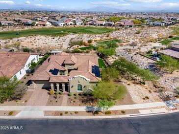 Stunning aerial view of a Southwestern home near a golf course, showcasing its tile roof and desert landscaping at 5033 N 205Th Gln, Buckeye, AZ 85396