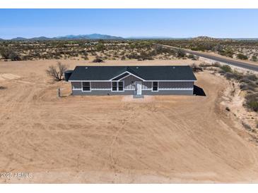 A well-maintained home featuring desert landscaping and an asphalt shingle roof at 51134 W Bluejay St, Maricopa, AZ 85139