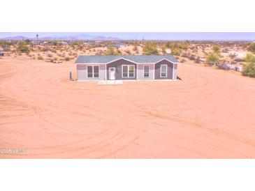 Charming single story home with a gray roof and matching trim in a desert landscape at 51942 W Sotol Rd, Maricopa, AZ 85139