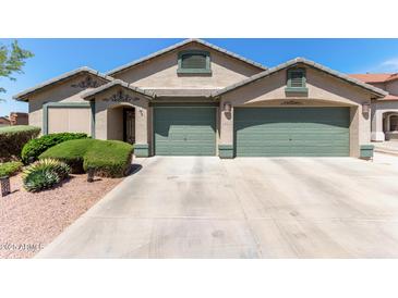Charming home featuring a neutral color scheme, well-kept landscaping, and a spacious three-car garage at 6002 N 124Th Dr, Litchfield Park, AZ 85340