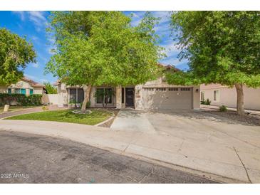 Charming home featuring a well-maintained lawn, mature trees, and a spacious two-car garage, enhancing curb appeal at 605 S Monterey St, Gilbert, AZ 85233