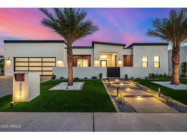Stunning modern home with a landscaped front yard, walkway lighting, and a gated entrance at 8549 E Indianola Ave, Scottsdale, AZ 85251