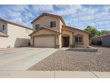Two-story home featuring a two-car garage and low maintenance desert landscaping at 12513 W Dreyfus Dr, El Mirage, AZ 85335